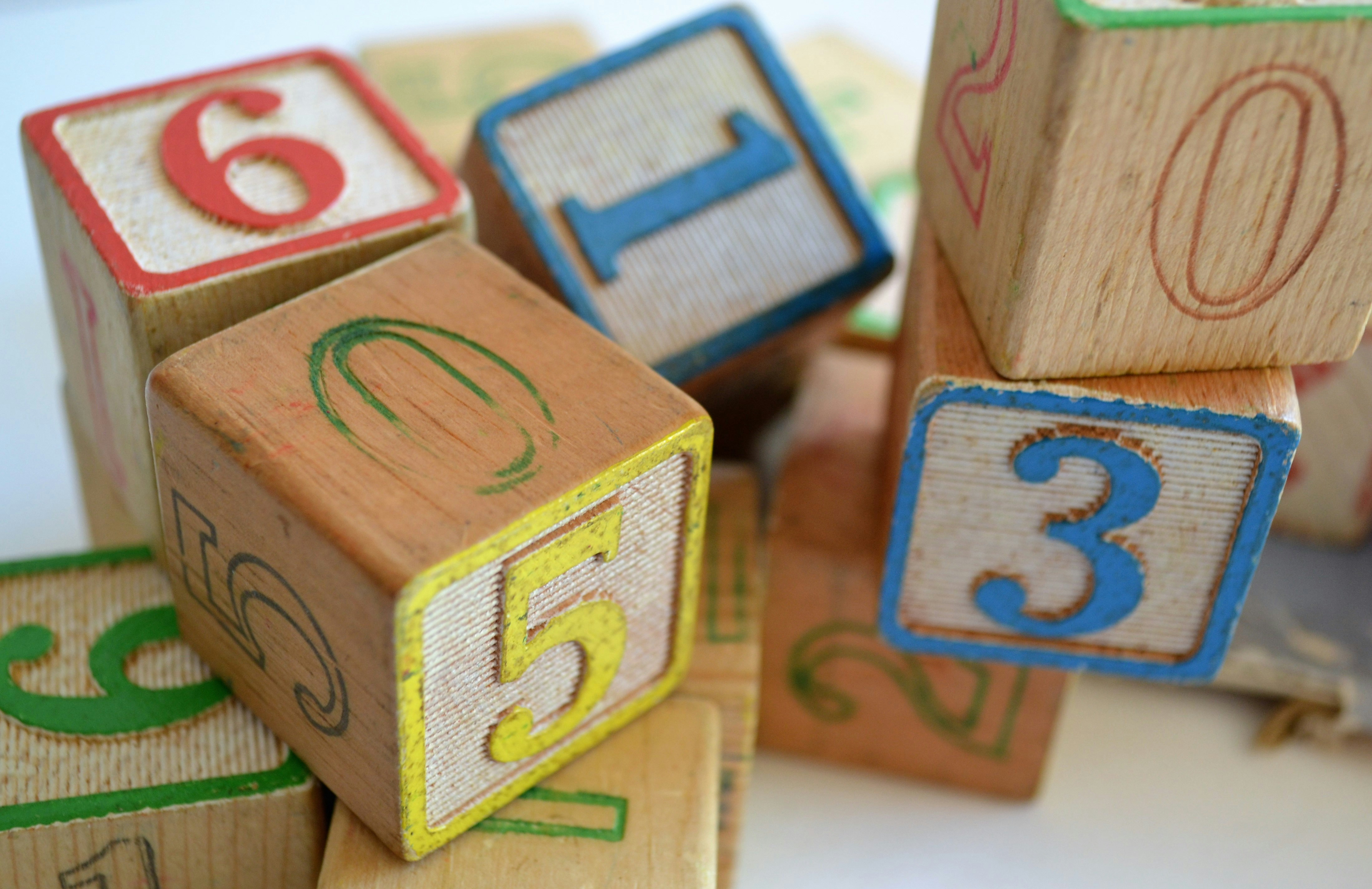 Gestion comptable et budgétaire pour institutions de la petite enfance — finidoo. Blocs éducatifs numérotés en bois, symbolisant la gestion comptable et budgétaire proposée par finidoo pour les institutions de la petite enfance.